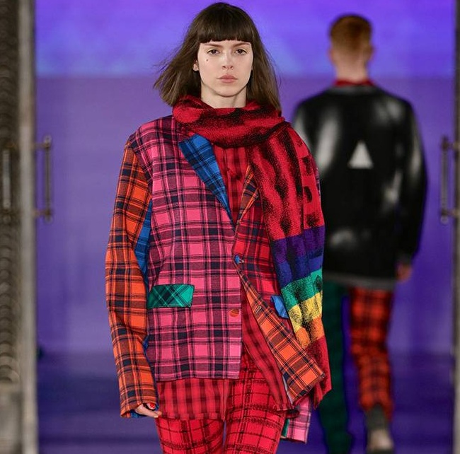Johan Ku Gold Label 2019 秋冬《Sean》系列於倫敦時裝週發表，模特兒身穿彩虹格紋拼接西裝與紅色粗針織圍巾